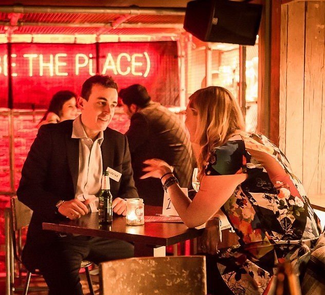 Dos personas conversando en una mesa de un bar